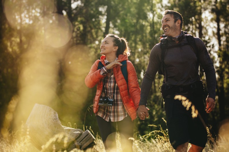 Couple going to their camping site in forest